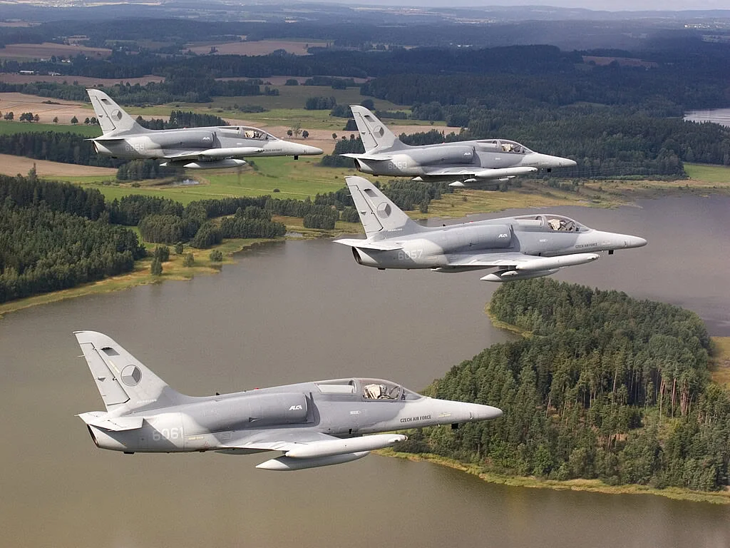 Чотири чеські бойові літаки L-159 у строю над полями та озером