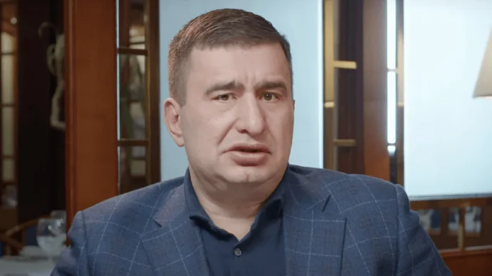 Екснардеп у синьому костюмі в кабінеті фіктивного підприємства Закарпаття
