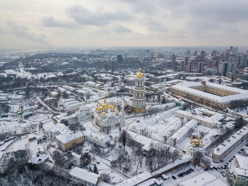 Засніжений Київ з золотими куполами лаври під хмарним небом, сильні морози 31 січня