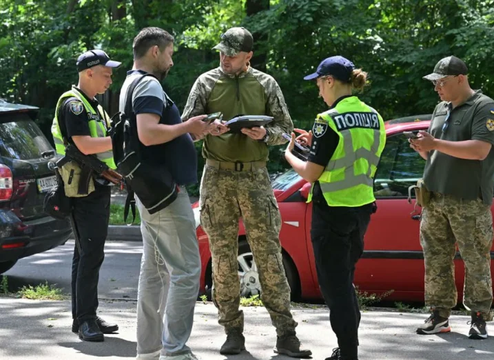 Патрульные и военные ТЦК проверяют документы возле остановленного авто во время мобилизации