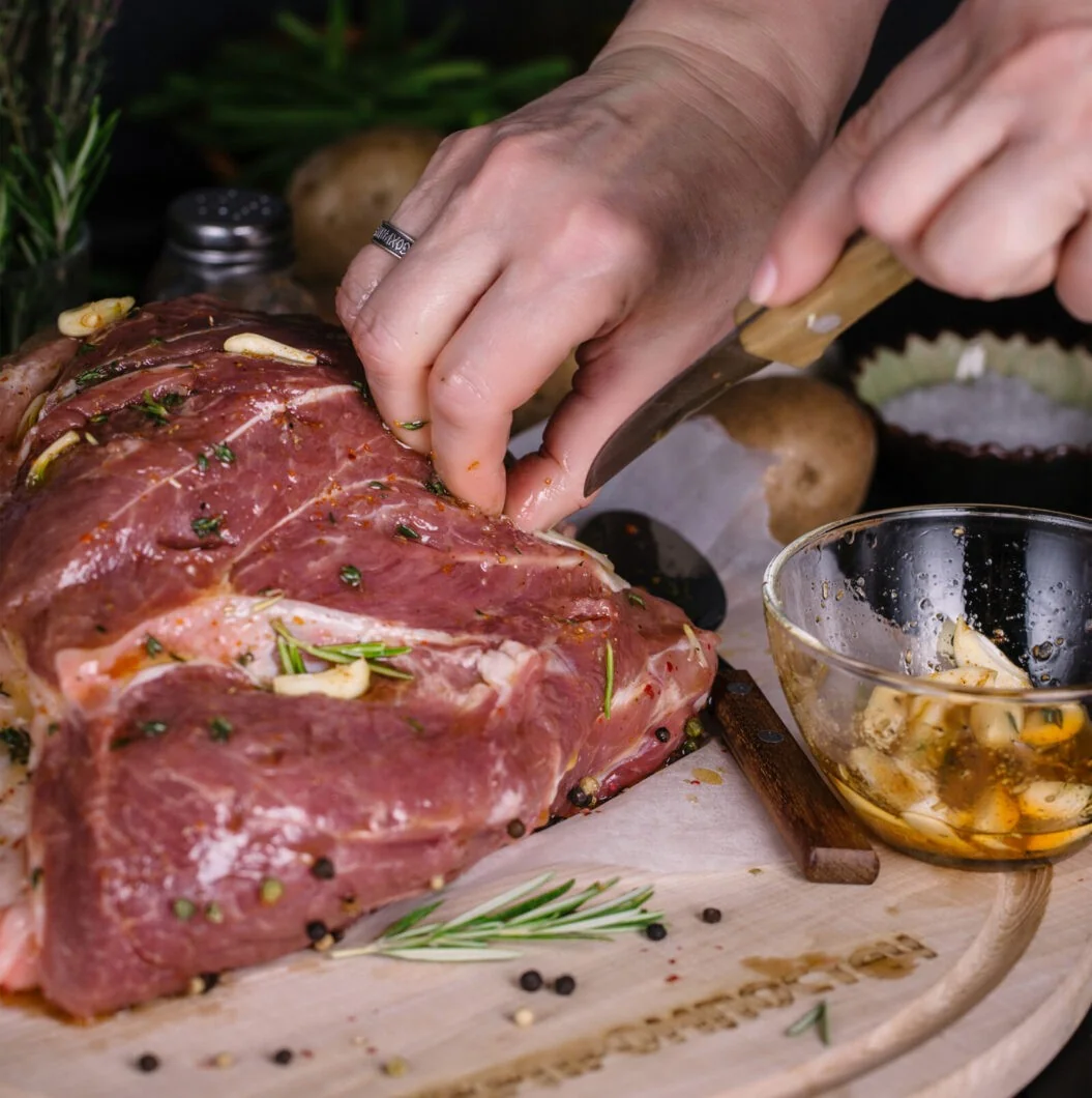 Руки солять сире мясо сіллю та розмарином для соковитості