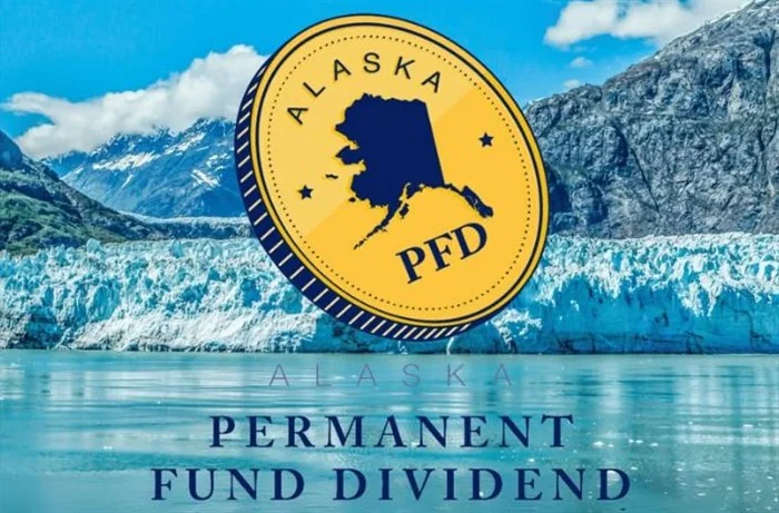Золота монета Аляски Permanent Fund Dividend (PFD) над горами, льодовиком і небом