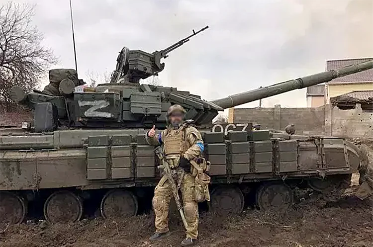 Украинский боец у трофейного российского танка с символом Z на фронте