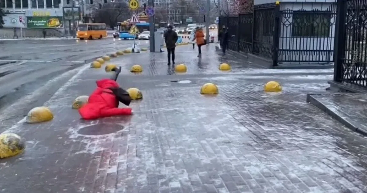 Ожеледиця на дорогах Києва 26 лютого: жінка в червоному впала на слизькому тротуарі