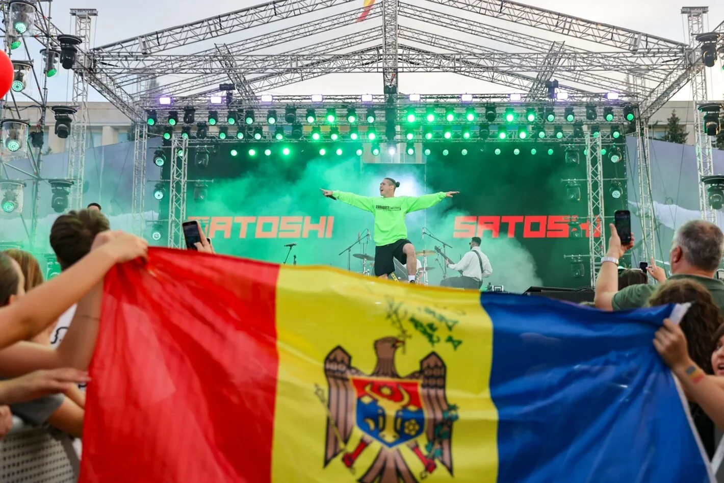 Молдовський Satoshi виступає на сцені під молдовським прапором натовпу
