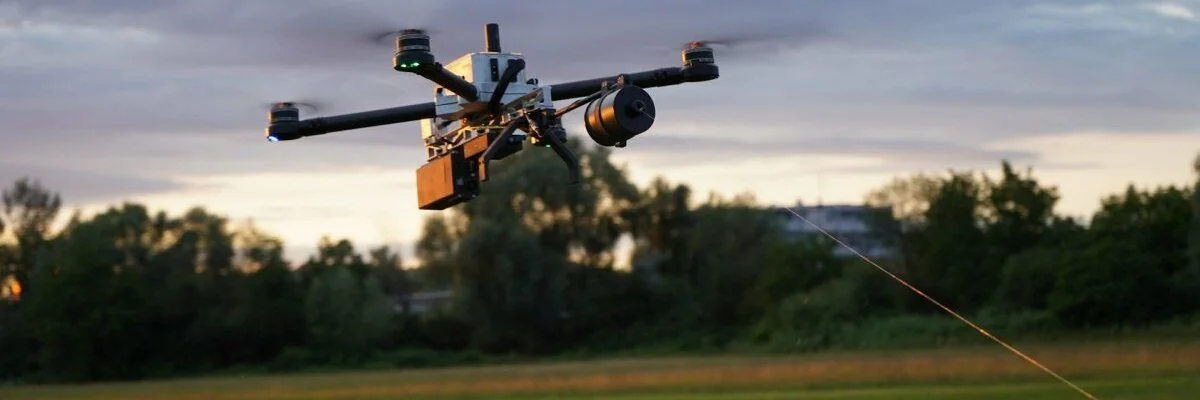 Оптоволоконний FPV-дрон у польоті з кабелем над полем під час атаки на Харків