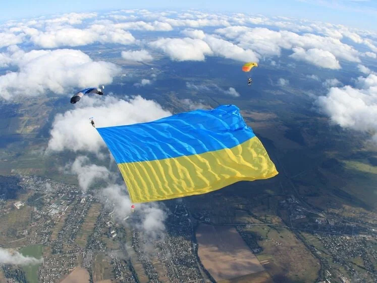 Парашютист с украинским флагом в небе над Киевом