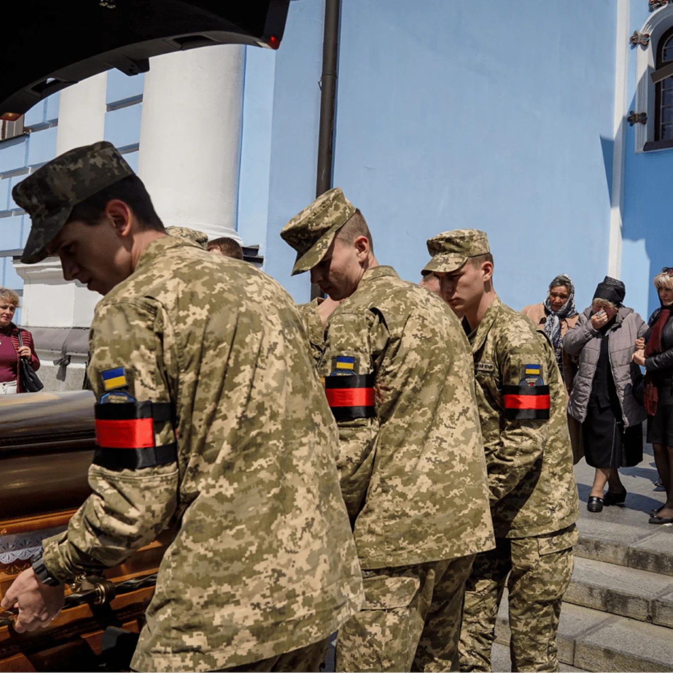 Військові ЗСУ несуть труну загиблого бійця під прапором України на похоронах