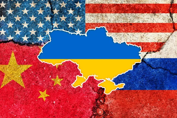 Розірваний прапор США з контуром України між прапорами Китаю та Росії