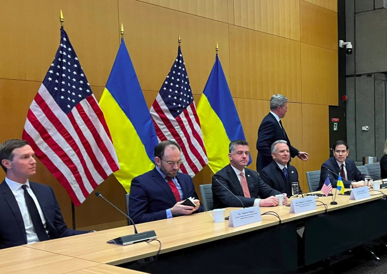 Американська делегація з прапорами США та України на переговорах у Женеві