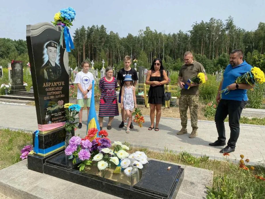 Ярослав Грубич з родиною вшановує сестру-близнючку Ольгу квітами на могилі