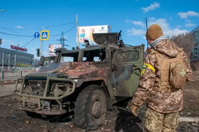 Військовий ЗСУ біля пошкодженого БТР у зруйнованому Вовчанську Харківської області