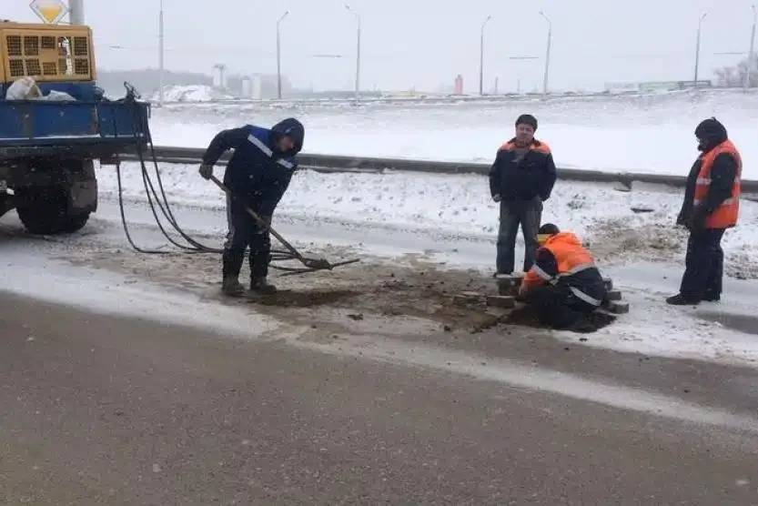 Робітники асфальтують яму на вул. Левка Лукяненка в Києві при -6°C серед снігу