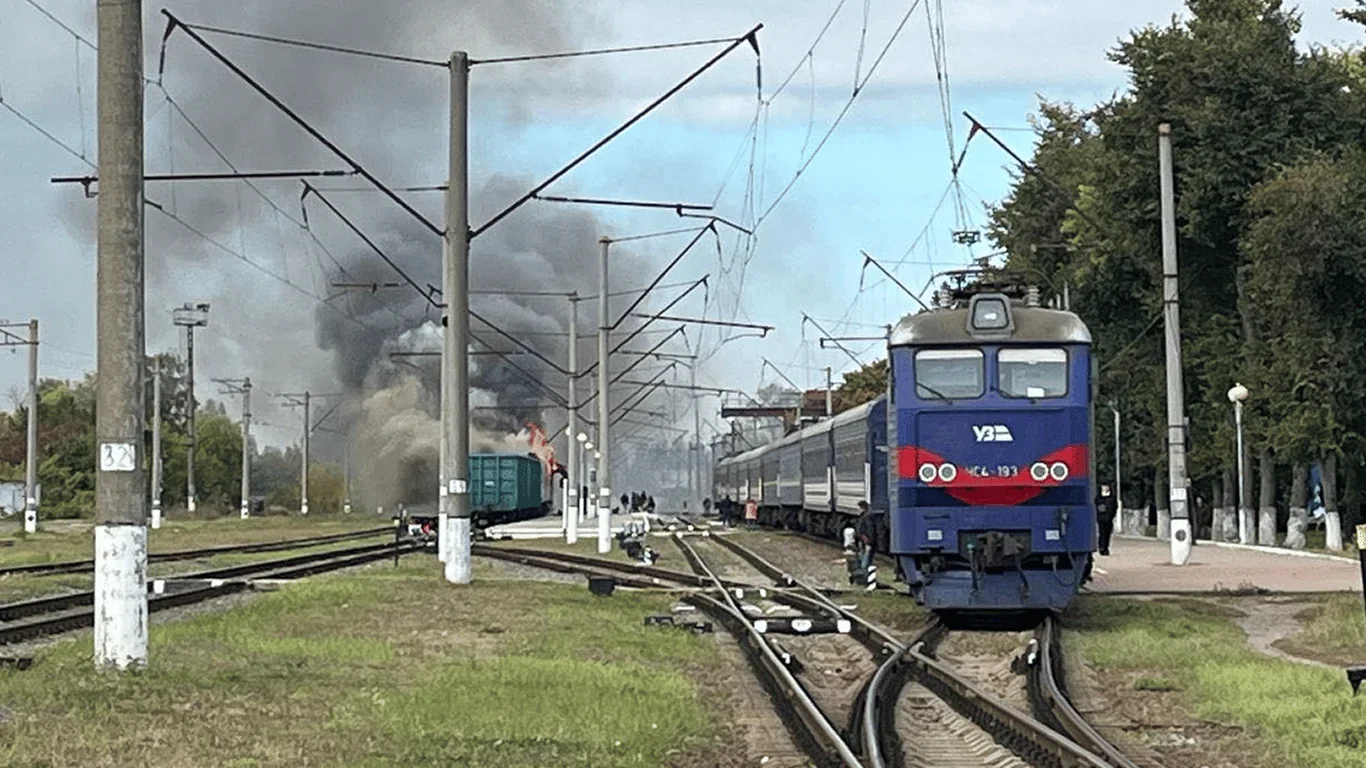 Поїзд Укрзалізниці на станції серед диму від ворожої атаки на залізницю