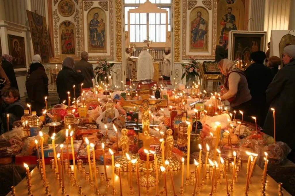 Стол с коливо и зажжёнными свечками на Вселенскую родительскую субботу в церкви