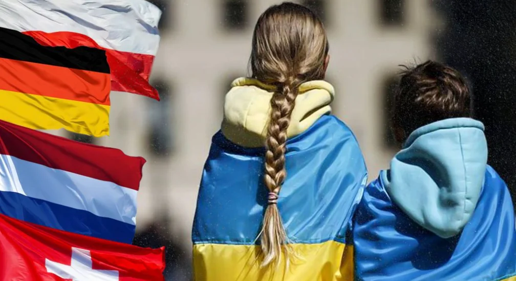 Украинские дети-беженцы в сине-желтых куртках среди флагов Германии, Польши, Швейцарии.