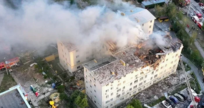 Вибух дрона у дворі запорізької багатоповерхівки: дим, уламки, рятувальники.