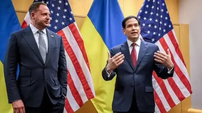 Владимир Зеленский и Марко Рубио на фоне флагов Украины и США