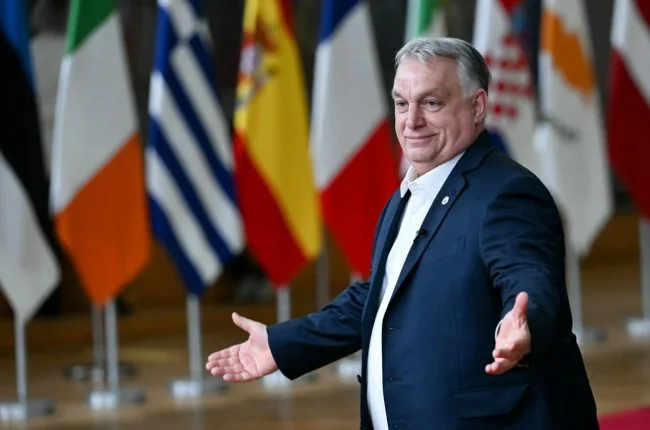 Віктор Орбан жестикулює руками перед прапорами країн ЄС