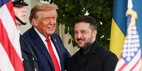 Владимир Зеленский и Дональд Трамп улыбаются на фоне флагов США и Украины