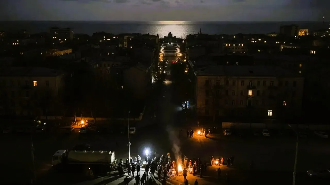 Темні вулиці Одеси вночі під час блекауту, люди біля вогнищ біля моря