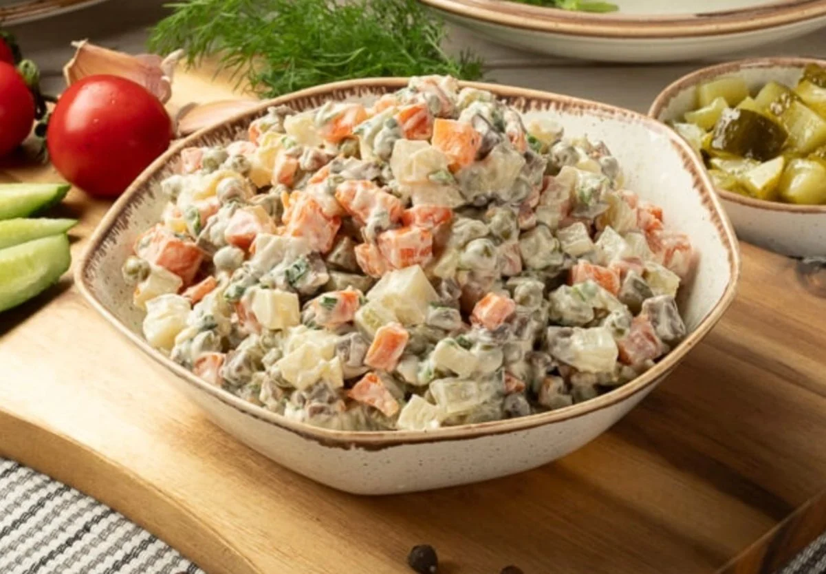 Постный салат «Оливье» без мяса и яиц в миске с картофелем, морковью и зеленью