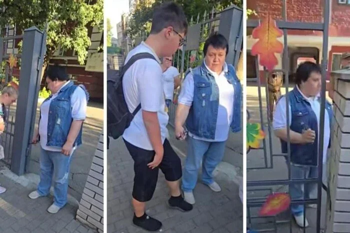 Учительница держит за руку 11-классника возле школьных ворот после скандала с угрозой окопами