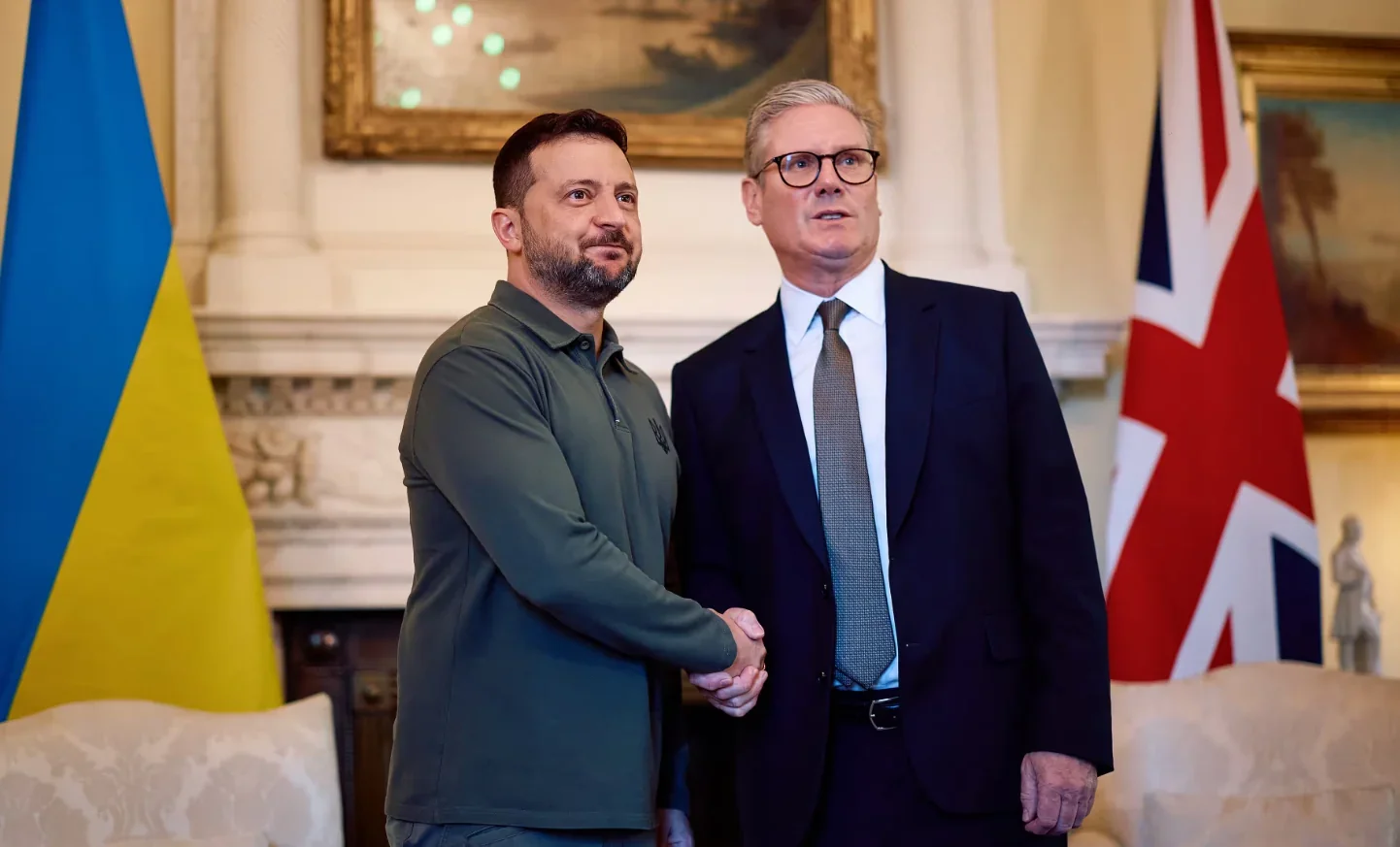 Кір Стармер і Володимир Зеленський потискають руки перед прапорами України та Великобританії
