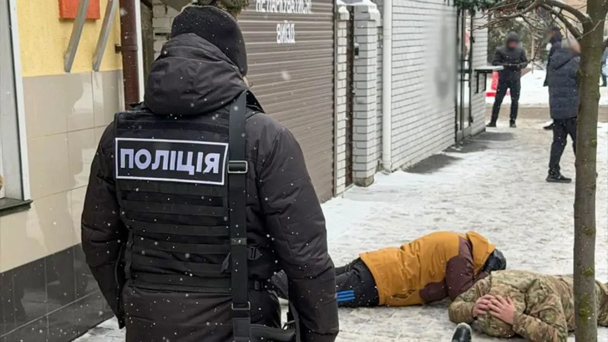 В Виннице полицейский стоит над избитым мужчиной в камуфляже на снегу