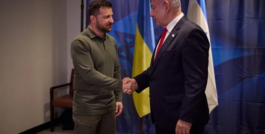 Володимир Зеленський тисне руку Емманюелю Макрону біля прапорів України та Франції