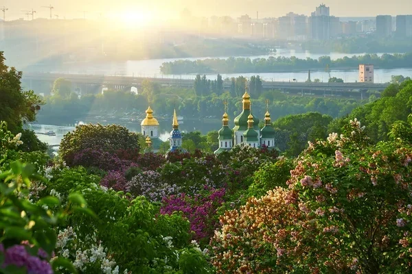Весняний краєвид України з квітучими садами, золотими куполами церков та теплим сонцем