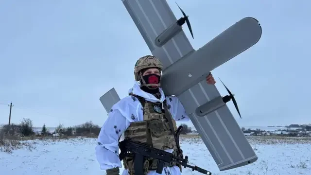 Воин ВСУ держит сбитый дрон «Молния» на Запорожском фронте