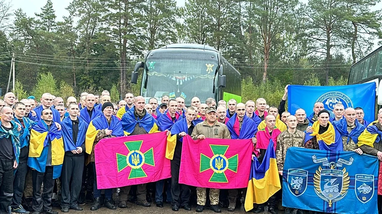 193 українські захисники з прапорами біля автобусу після повернення з полону