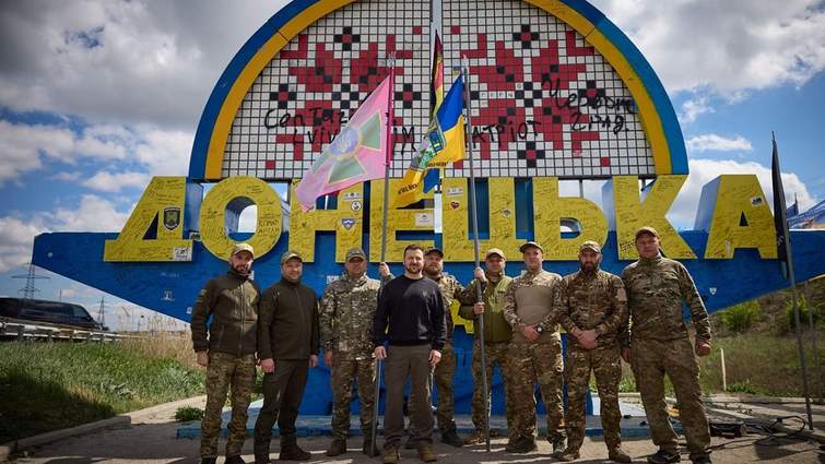 Володимир Зеленський з військовими біля знаку «Донецька область» на тлі прапорів