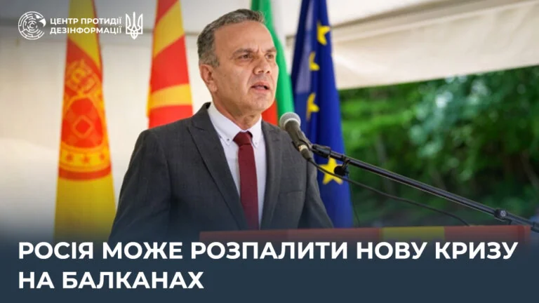 Витаутас Лешкавичюс выступает о российской гибридной агрессии с флагами Литвы, Германии и ЕС