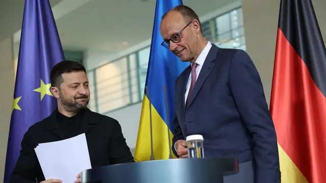 Володимир Зеленський та Фрідріх Мерц за трибуною під прапорами України й Німеччини