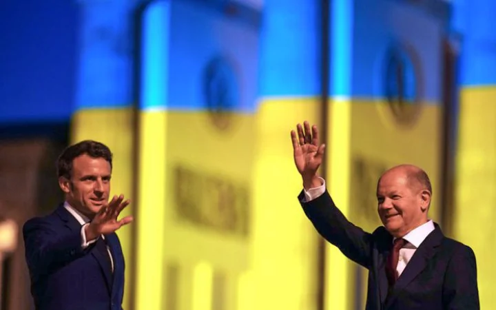 Президент Франції Макрон і канцлер Німеччини Шольц на тлі українського прапора