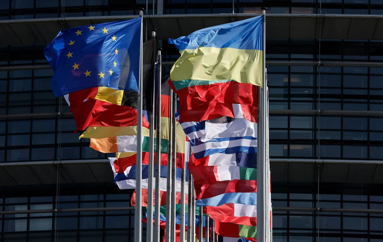 Прапори ЄС, України та Ізраїлю перед будівлею Євросоюзу символізують подвійні стандарти