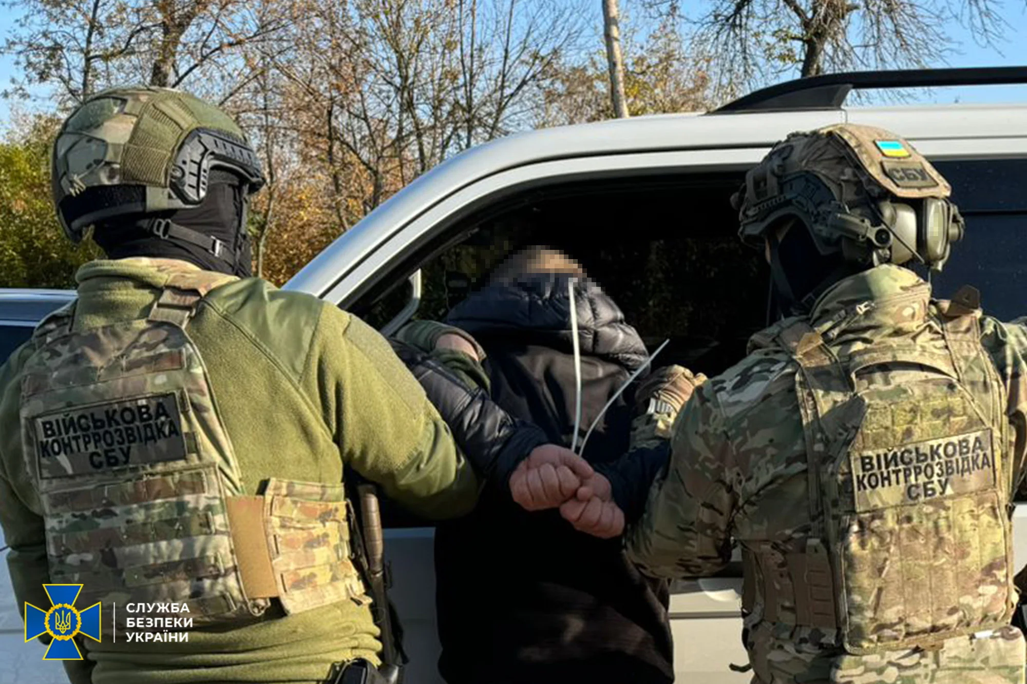 Сотрудники СБУ затаскивают шпиона оборонного завода в служебный автомобиль во время задержания