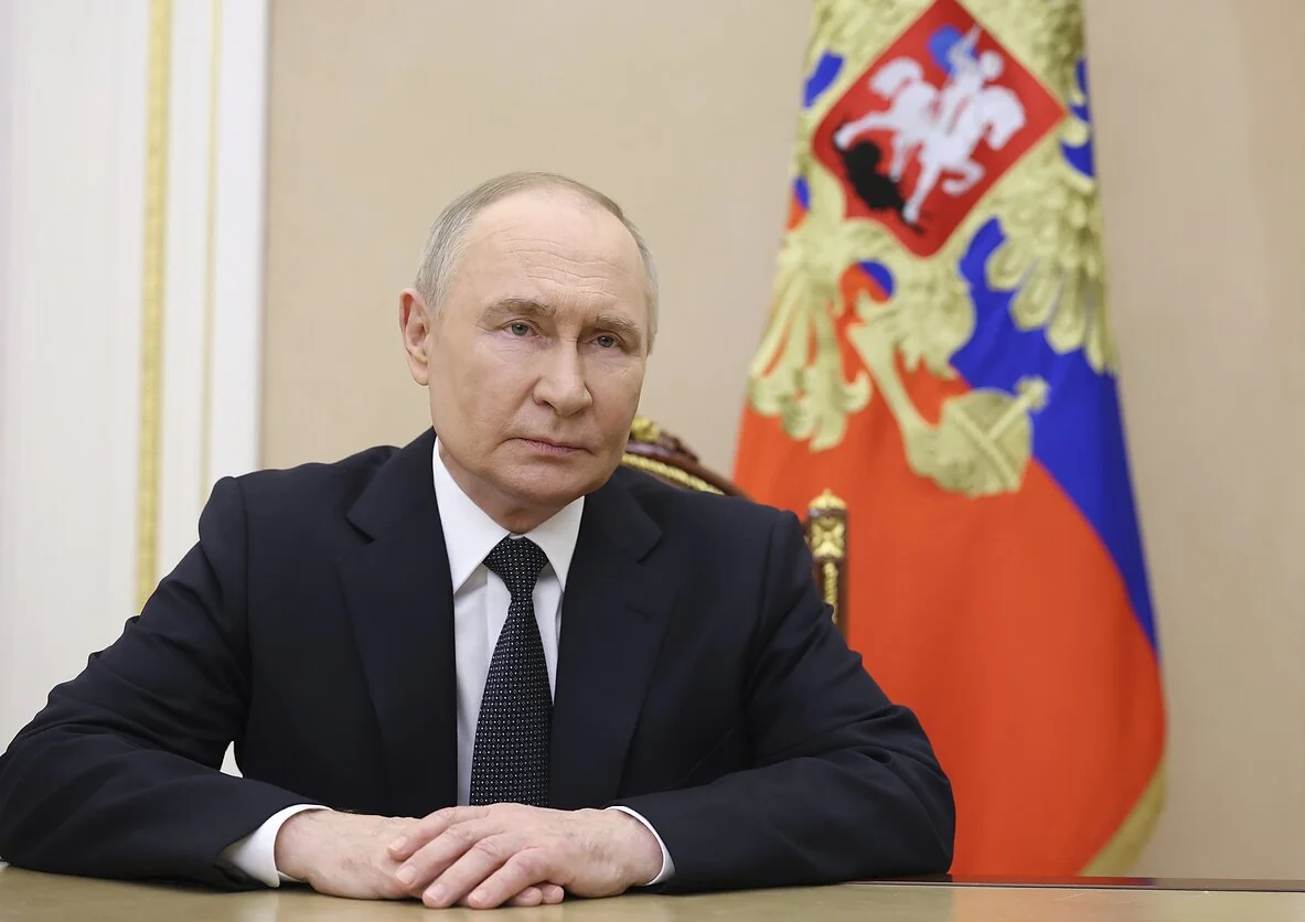 Владимир Путин за столом на фоне флага России в контексте переговоров