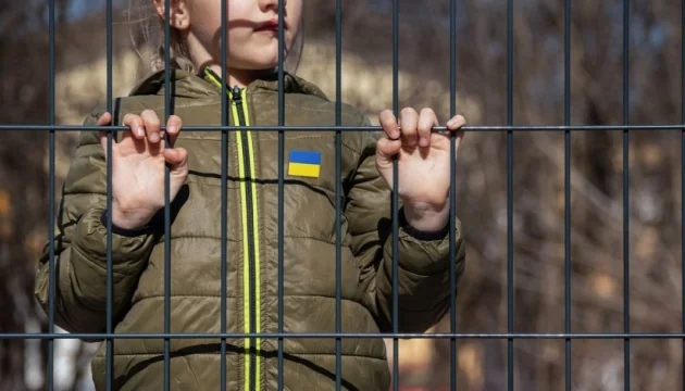 Украинский ребёнок за решёткой с флагом на куртке