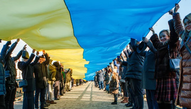 Громадяни тримають прапор України, символізуючи єдність народу