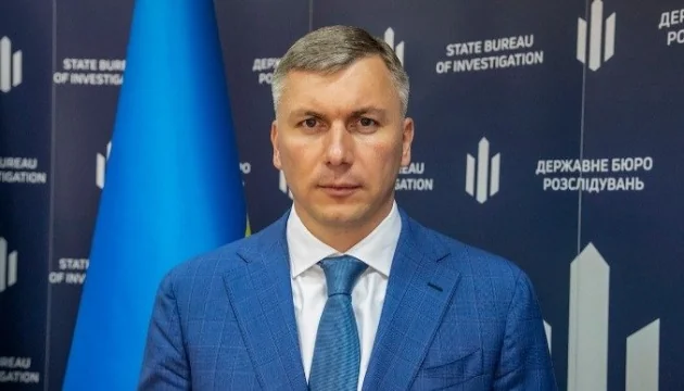 Директор ДБР Олексій Сухачов на тлі прапора та логотипів бюро