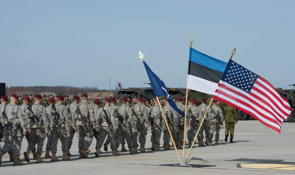 Американские военные в строю с флагами США и Эстонии на аэродроме