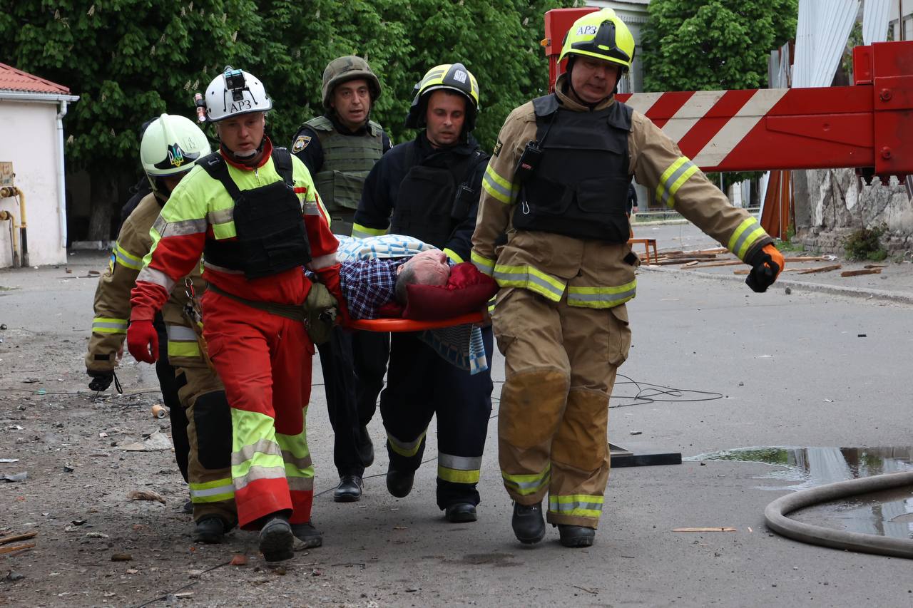 Рятувальники несуть пораненого на ношах після обстрілів Дніпропетровщини