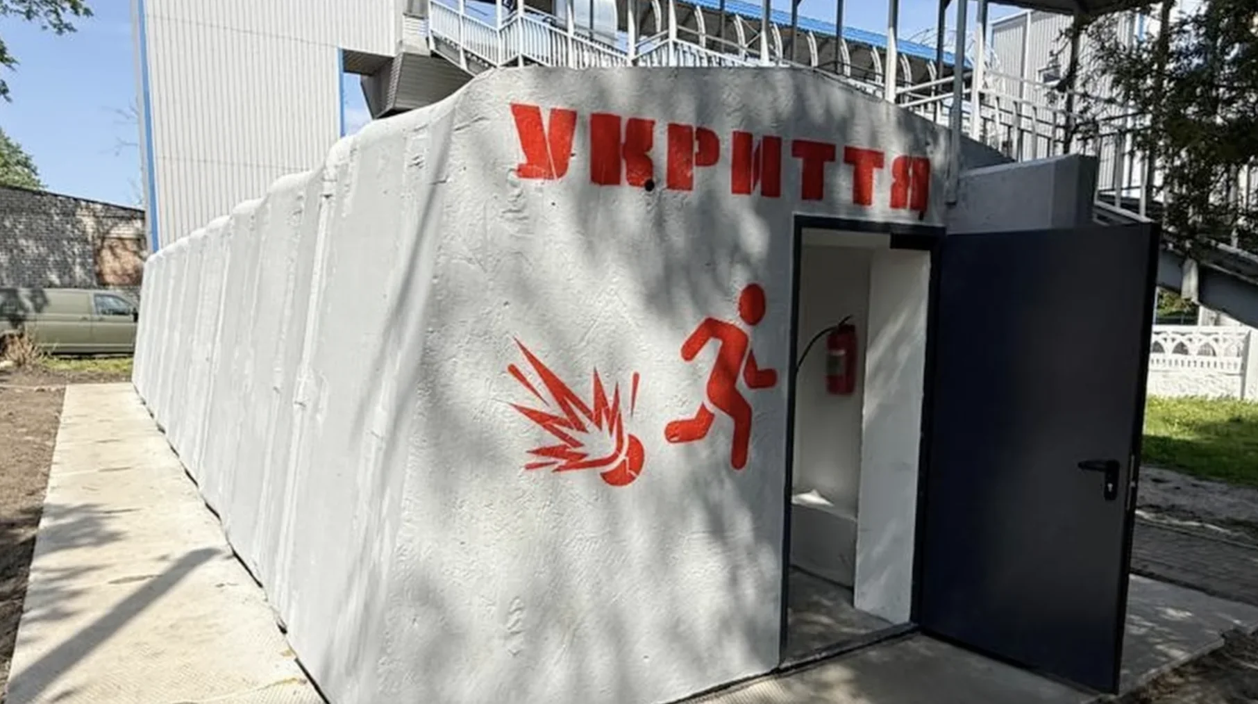 Бетонне укриття з написом УКРИТТЯ та знаком евакуації під час війни