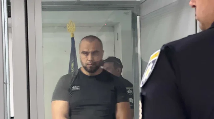 Максим Пілатов у скляній камері під вартою під час суду