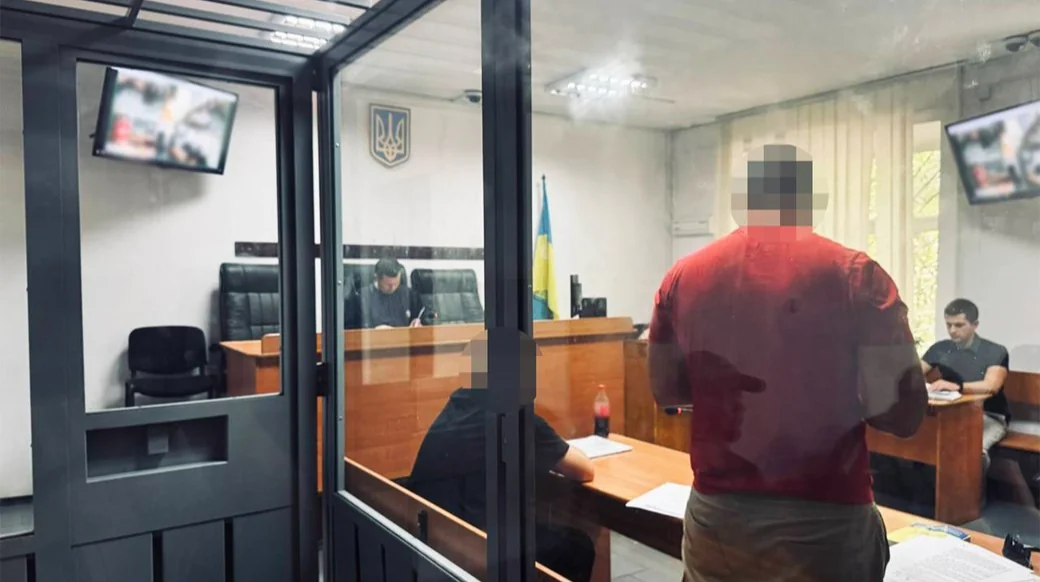 Судове засідання в залі з підозрюваним у червоній сорочці за склом