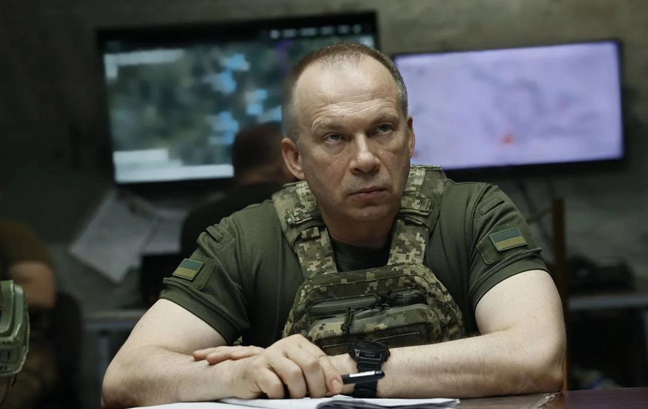 Олександр Сирський у формі за столом у командному пункті на тлі карт