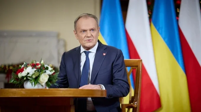 Дональд Туск за трибуною з прапорами Польщі та України під час заяви про допомогу Києву